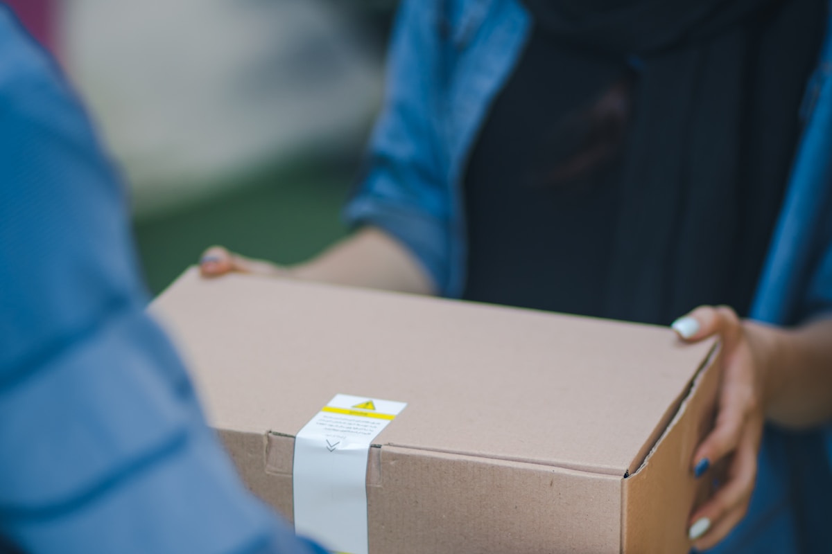 Worker scanning parcel barcodes inside a distribution warehouse
